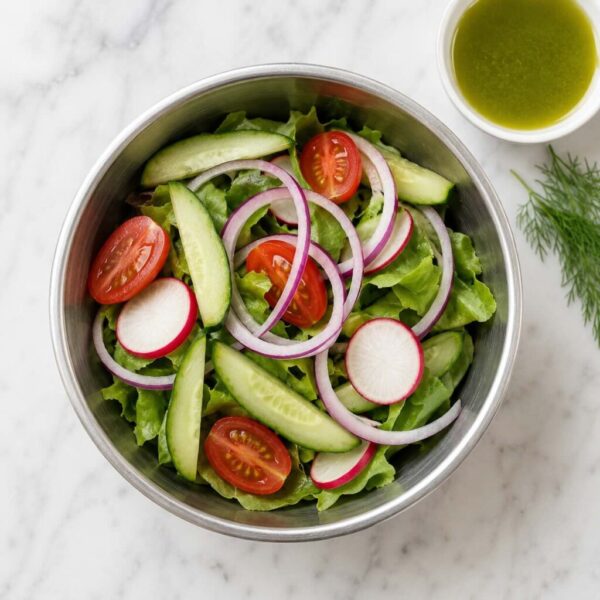 Fresh Ukrainian garden salad with lettuce, spinach, cucumber, tomato, radish, and onion.
